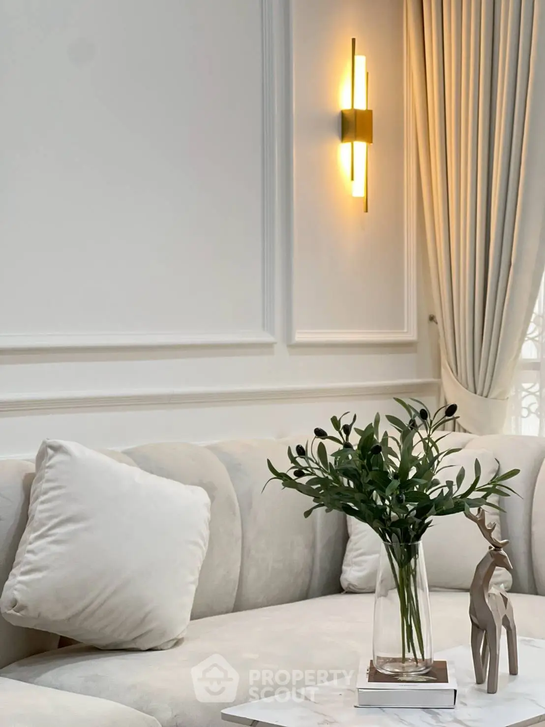 Elegant living room with plush sofa and modern wall light