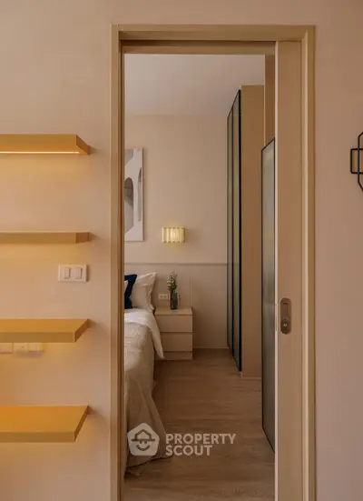 Cozy bedroom with modern design and warm lighting, featuring a sliding door and elegant decor.