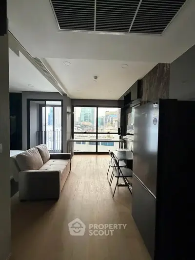 Modern apartment interior with open layout and city view, featuring sleek kitchen and cozy living area.