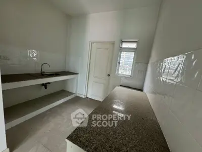 Compact kitchen with granite countertops and white tiled walls