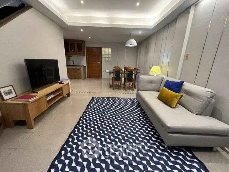 Spacious living room with modern decor and open kitchen layout