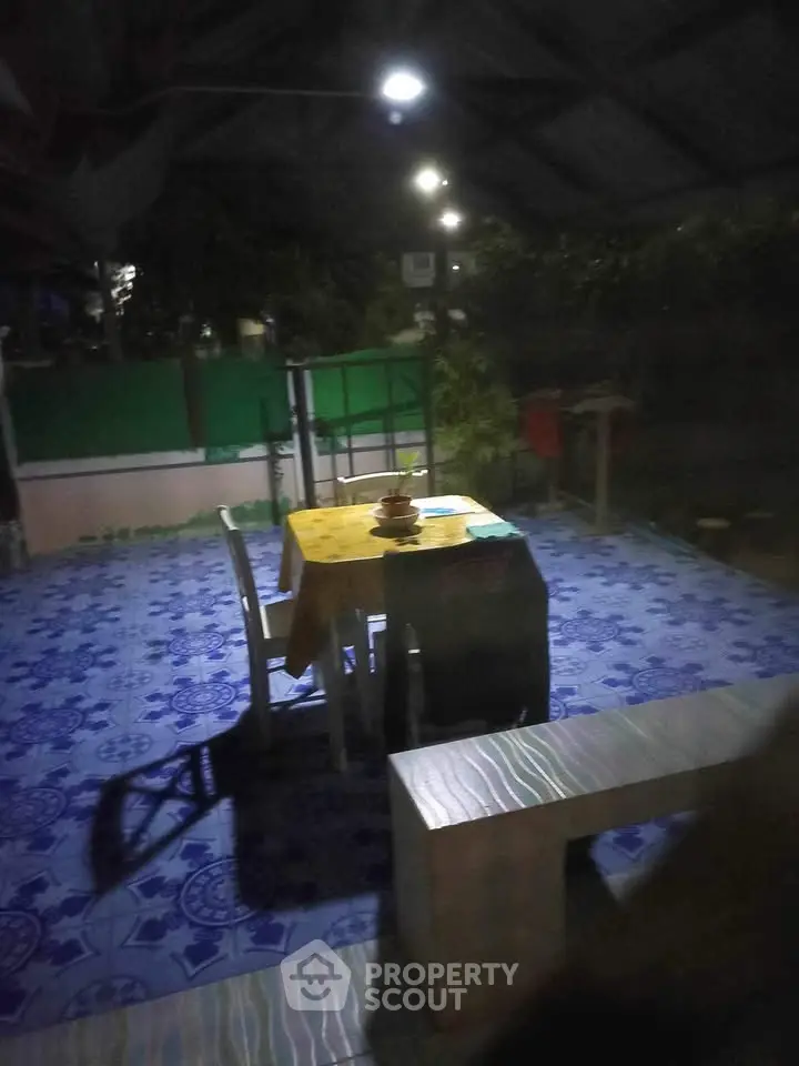 Charming outdoor patio with vibrant blue tiles and cozy dining setup.