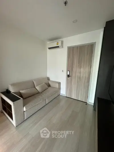 Cozy living room with modern sofa and air conditioning in a stylish apartment.