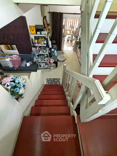 Charming multi-level home with red staircase and cozy living area, perfect for family gatherings.