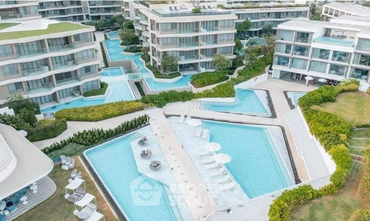 Luxurious modern apartment complex with stunning pools and lush landscaping.