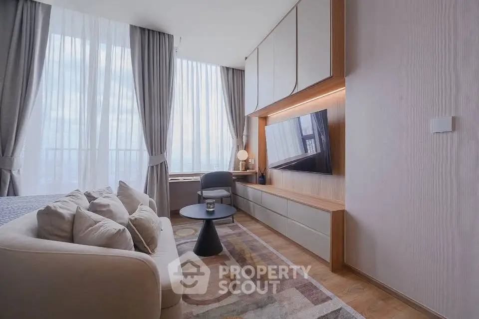 Modern living room with elegant decor, large windows, and stylish furniture in a high-rise apartment.