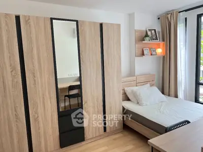 Modern bedroom with sleek wooden wardrobe and cozy bed, perfect for urban living.