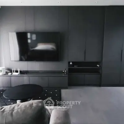 Modern living room with sleek black cabinetry and large wall-mounted TV
