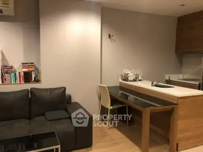 Modern living room with cozy sofa and stylish kitchen area, perfect for urban living.