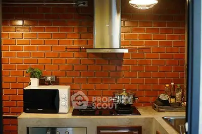 Chic kitchen with brick wall and modern appliances, featuring a gas stove and sleek design.