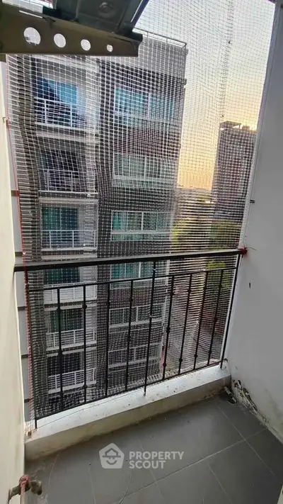 Urban balcony with safety netting and city view at sunset
