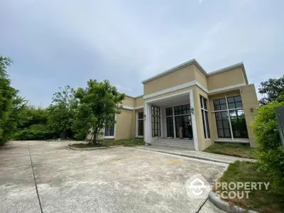 Modern single-story house with large windows and spacious driveway