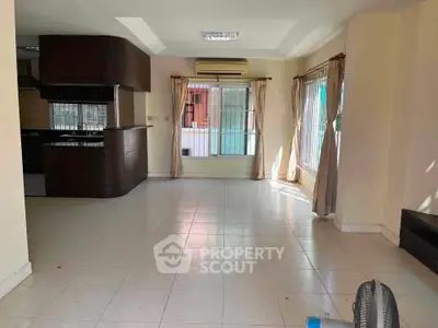 Spacious living room with large windows and open kitchen layout, perfect for natural light and modern living.