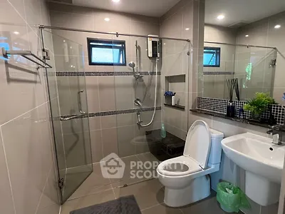 Modern bathroom with glass shower enclosure and sleek fixtures