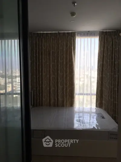 Cozy bedroom with large windows and elegant curtains in a modern apartment.