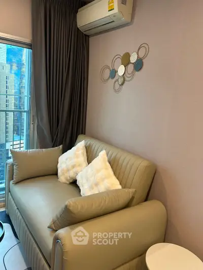 Cozy living room with modern decor and city view, featuring a stylish sofa and elegant wall art.