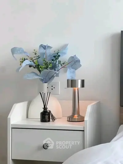 Elegant bedroom nightstand with modern lamp and floral decor