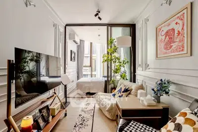 Chic living room with modern decor and cozy bedroom view, perfect for urban living.