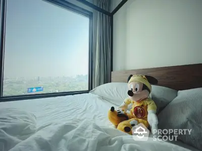 Cozy bedroom with city view and plush toy on bed