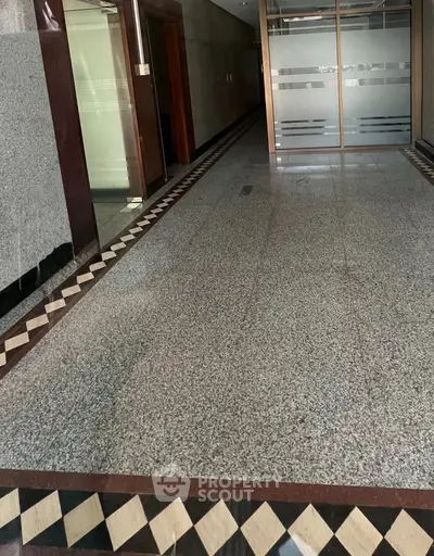 Elegant building entrance with polished granite flooring and modern glass doors