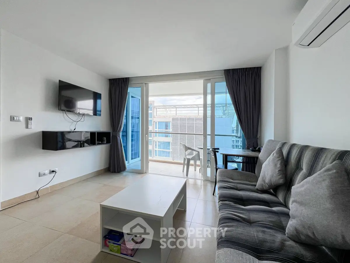 Modern living room with balcony view, featuring sleek furniture and natural light.