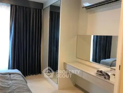 Modern bedroom with sleek design, featuring a large mirror and air conditioning unit.