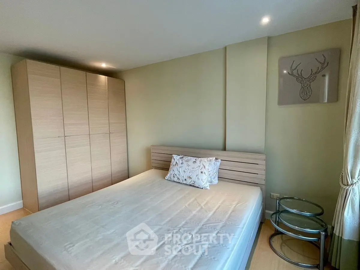 Modern bedroom with minimalist design featuring a wooden wardrobe and stylish decor.