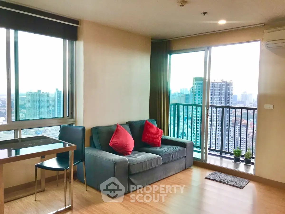 Modern living room with city view and stylish furniture in high-rise apartment.
