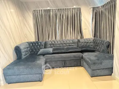 Luxurious living room with plush velvet sectional sofa and elegant curtains, perfect for relaxation and style.