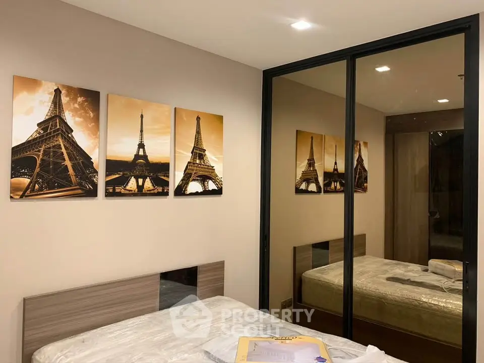Modern bedroom with mirrored closet and stylish Eiffel Tower artwork