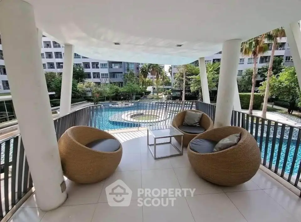Luxurious outdoor seating area overlooking a pristine pool in a modern residential complex.