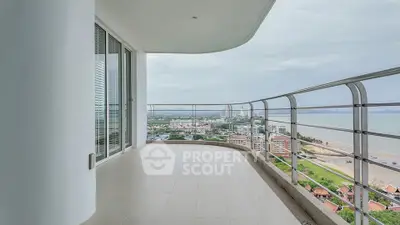 Spacious balcony with stunning ocean and city view in modern high-rise apartment.