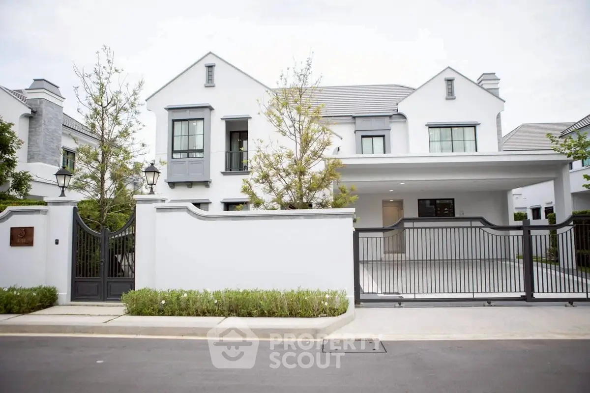 Elegant modern white house with gated entrance and manicured landscaping