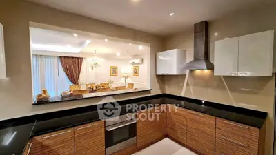 Modern kitchen with open layout and sleek appliances, overlooking elegant dining area.