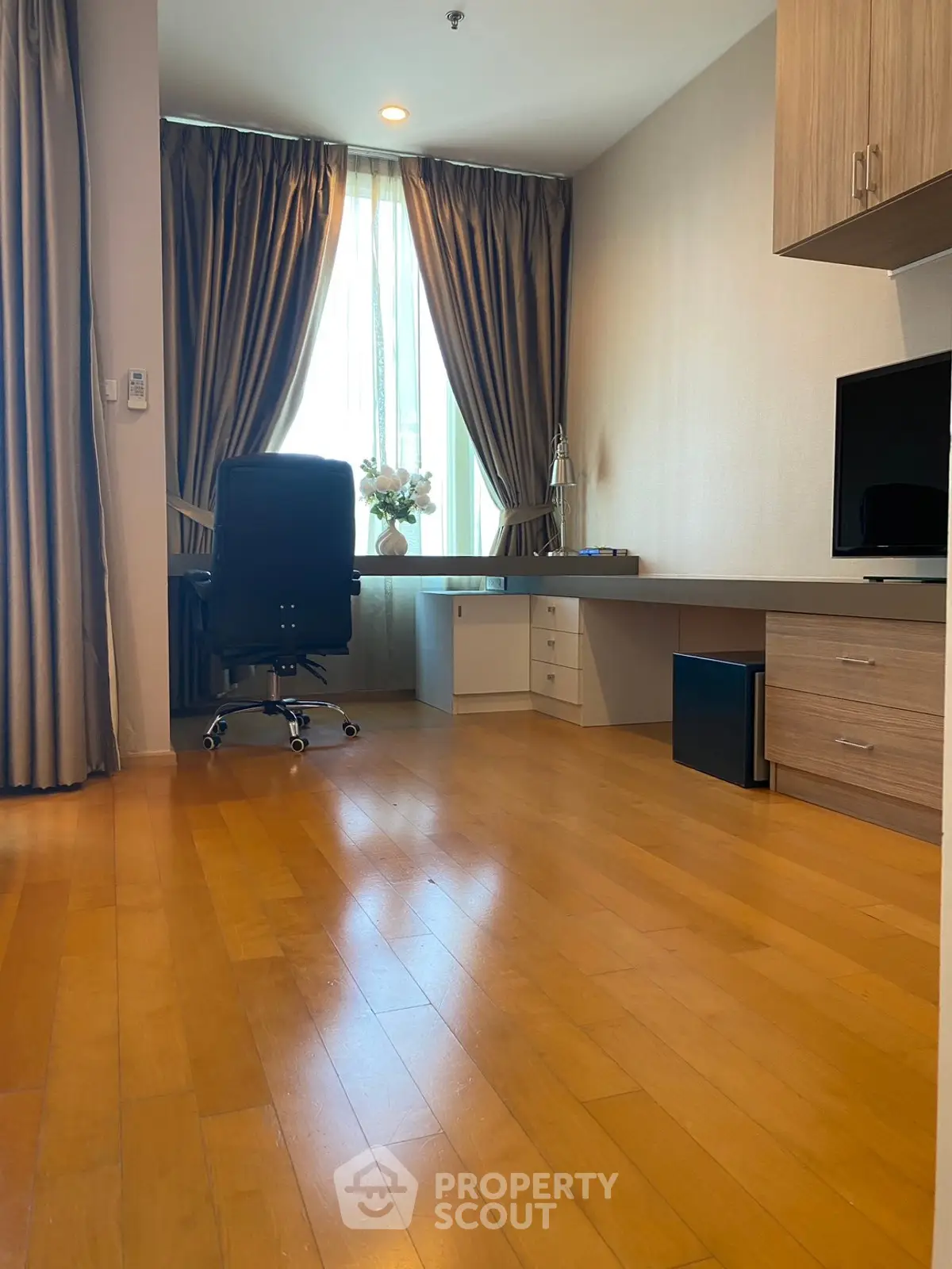 Spacious study room with wooden flooring and modern desk setup