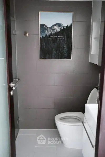 Modern bathroom with sleek design and mountain artwork on wall.