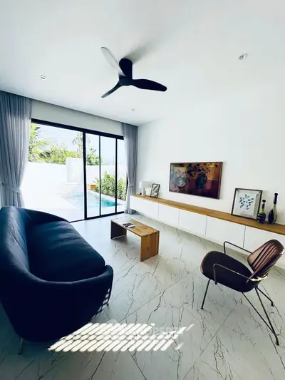 Modern living room with sleek furniture and pool view, featuring a stylish ceiling fan and elegant decor.