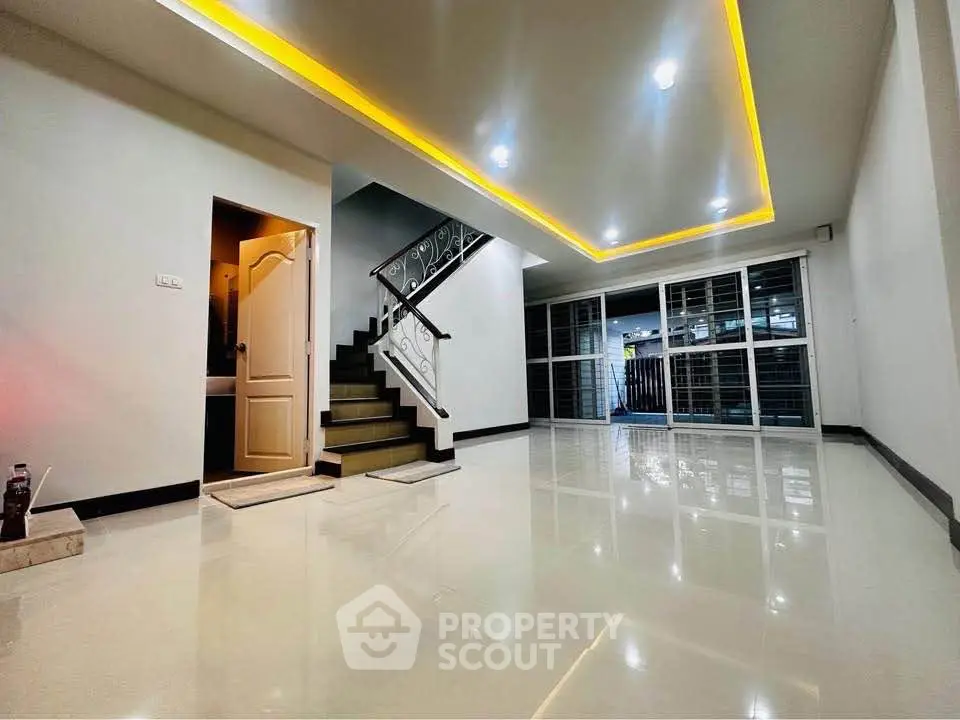 Spacious modern living room with glossy floors and stylish staircase