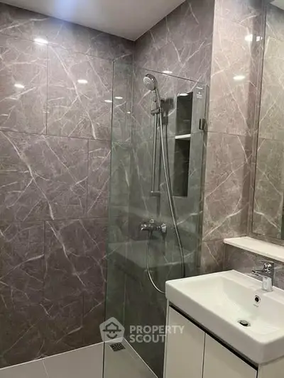Modern bathroom with sleek glass shower and elegant marble tiles
