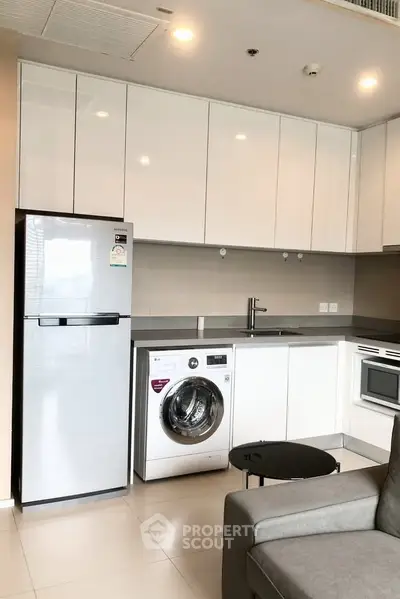 Modern kitchen with sleek appliances and stylish cabinetry in a contemporary apartment.