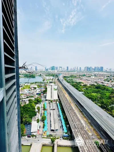 Stunning cityscape view from high-rise building overlooking highway and urban skyline.