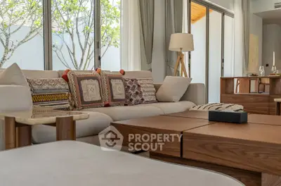 Luxurious living room with elegant decor and large windows offering natural light.