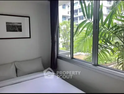 Cozy bedroom with large window and garden view in modern apartment