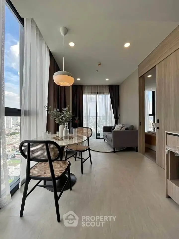 Modern living room with floor-to-ceiling windows and stylish dining area in a high-rise apartment.