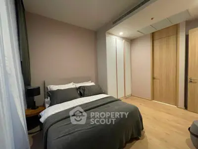 Modern bedroom with cozy bedding and sleek wooden flooring