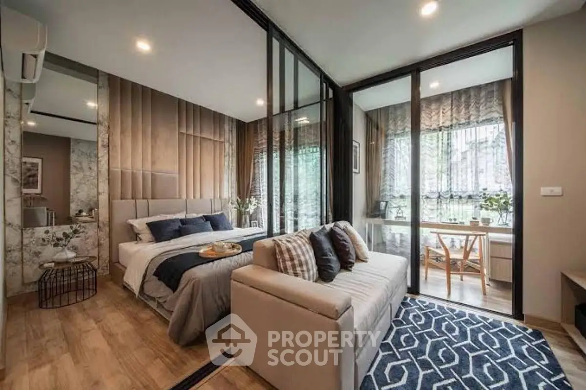 Modern bedroom with stylish decor and cozy seating area, featuring large windows for natural light.