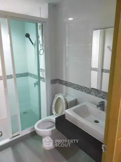 Modern bathroom with sleek design, glass shower enclosure, and stylish fixtures.