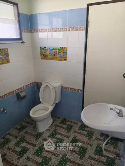 Charming bathroom with colorful tile accents and natural light, perfect for a cozy home ambiance.