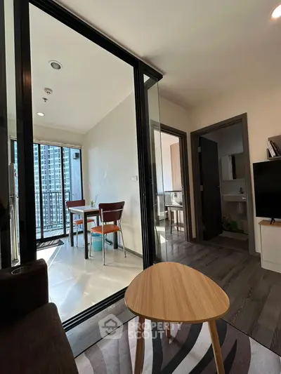 Modern apartment with open living and dining area featuring a balcony view.