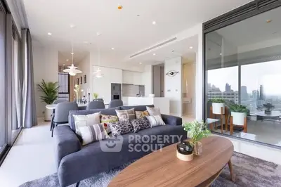 Luxurious modern living room with open kitchen and city view balcony.